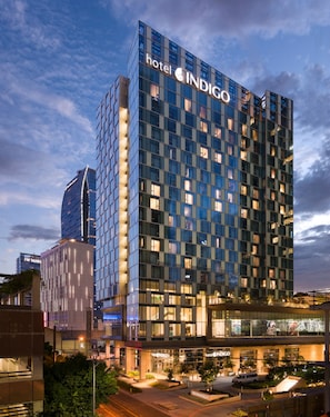 Un moderno edificio de hotel con un llamativo letrero que dice 'hotel INDIGO'.