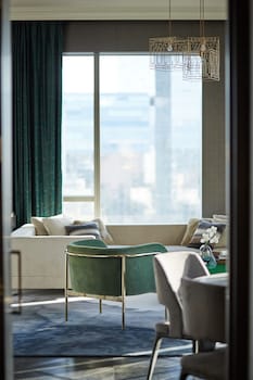 A modern hotel with a glass facade, surrounded by high-rise buildings and a busy road. at Hotel Indigo Los Angeles Downtown by IHG
