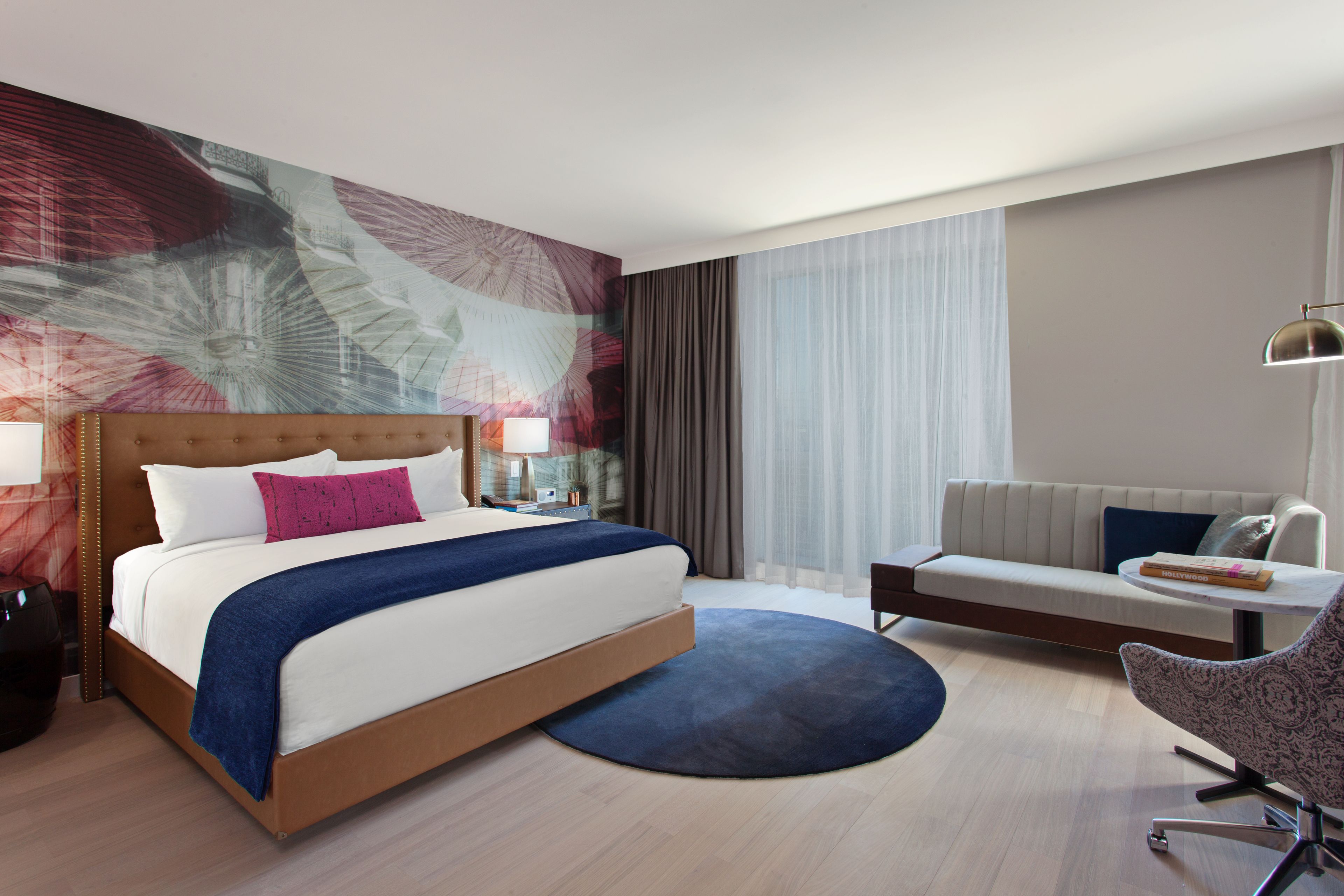 Una habitació d'hotel amb un llit gran, un sofà, un escriptori i una cadira.