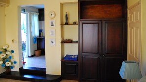 A hallway with a wooden cabinet, a clock, and a lamp. - Marisa Residences (La Gaulette)