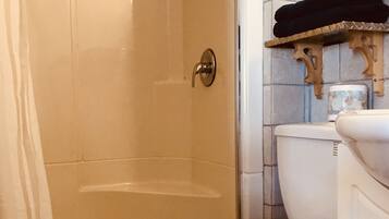 A bathroom with a shower, toilet, and sink.