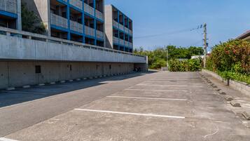A parking lot with concrete barriers and a building with blue accents in the background.