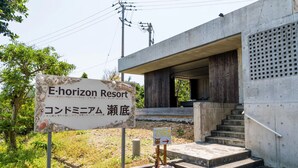 A sign for E-horizon Resort with Japanese text, a small directional sign, and a concrete staircase leading to a building entrance. - HOTEL E-horizon Resort Condominium Sesoko (Motobu)