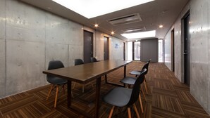 A conference room with a long table, six chairs, and a high ceiling with skylights. - HOTEL E-horizon Resort Condominium Sesoko (Motobu)