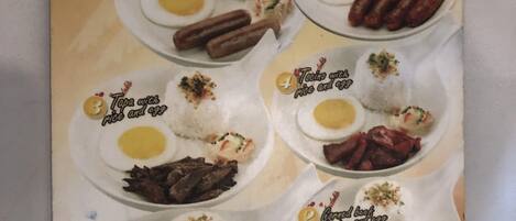 Menú de desayuno del Shore Time Hotel Boracay que incluye langoniza con arroz y huevo, tapa con arroz y huevo, y pescado frito con arroz y huevo.