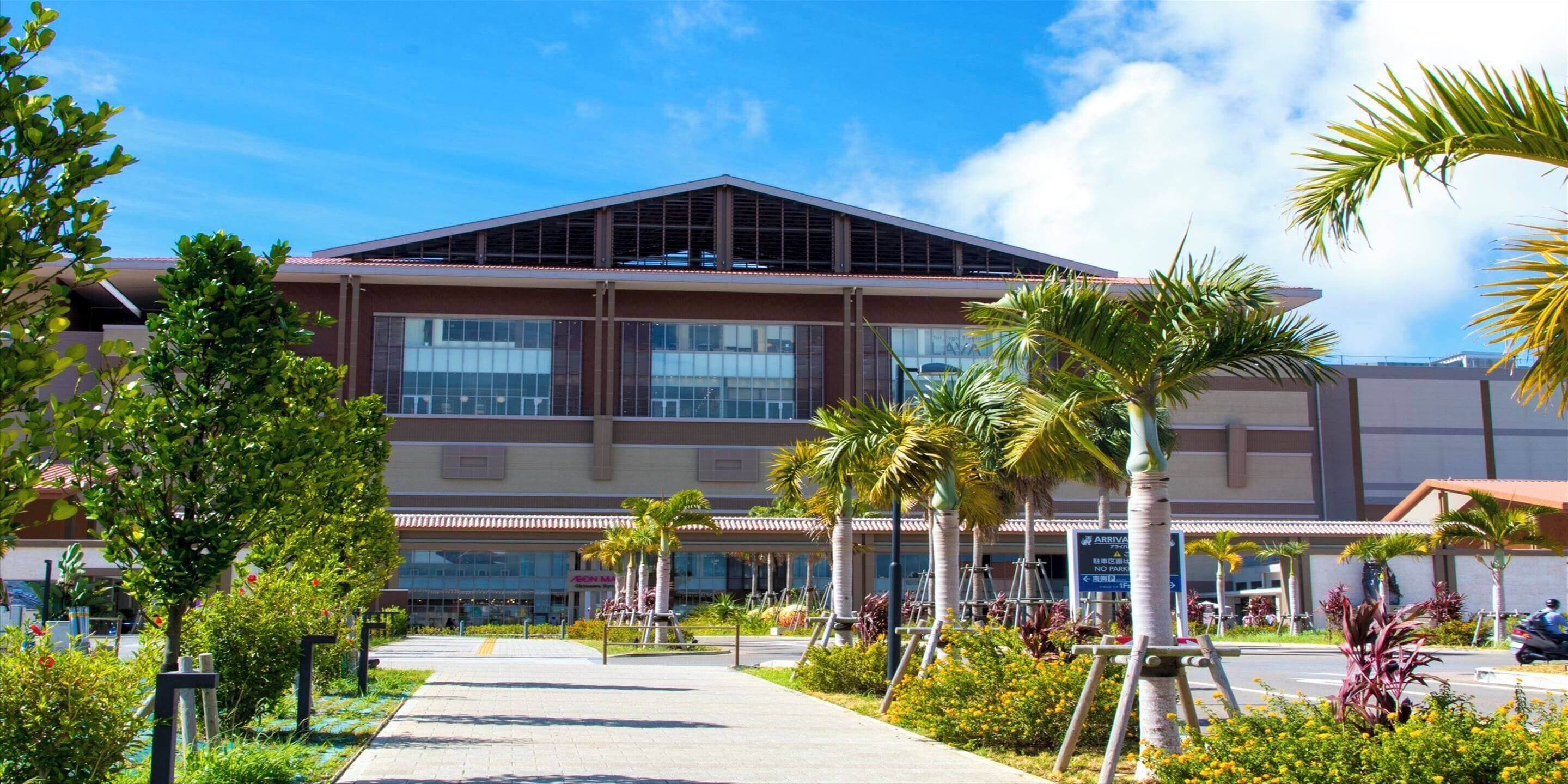 A modern building with a flat roof, large windows, and a covered entrance area.