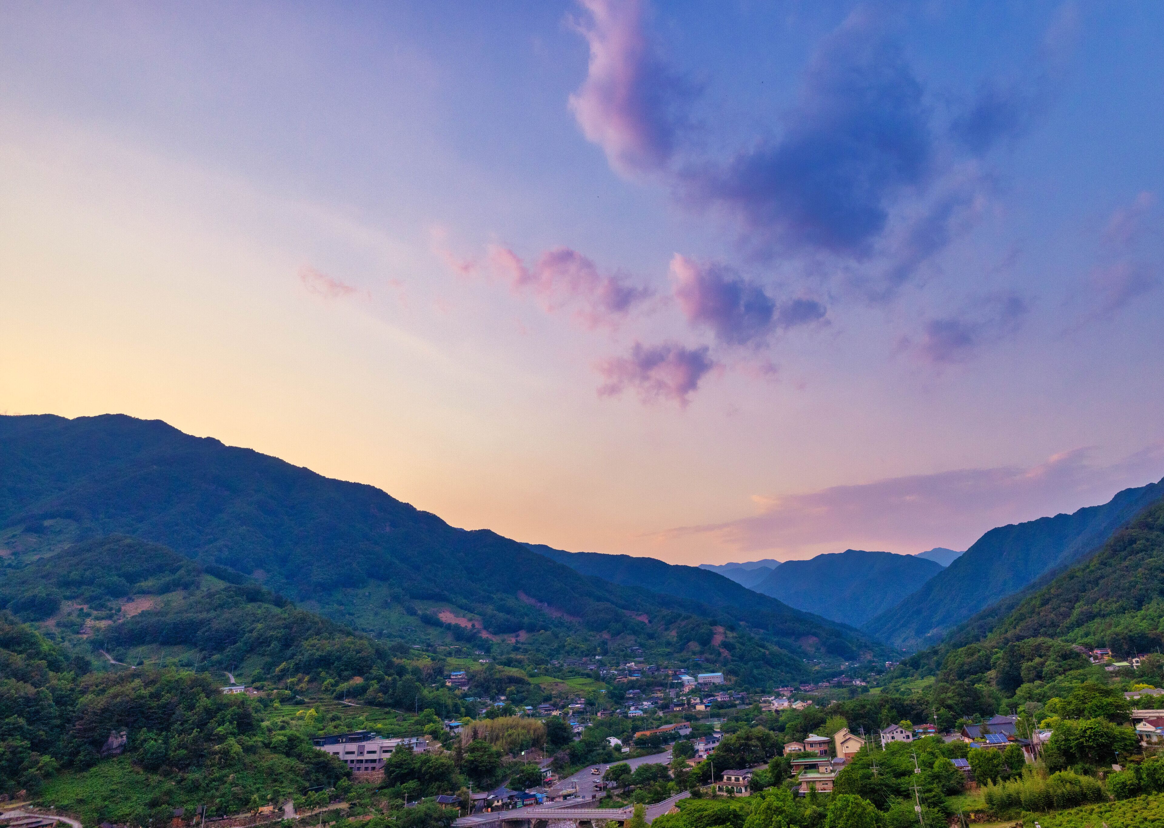 Un paisaje montañoso con un pequeño pueblo enclavado en el valle.