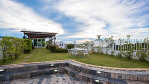 A patio with stone steps and a pergola, surrounded by a white fence and greenery. - Arisara Place (Koh Samui)