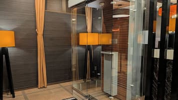 A modern elevator with glass doors, a wooden panel wall, and a black and white striped rug.