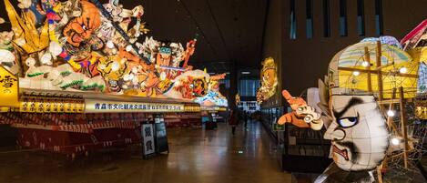 Un vaste espace intérieur doté d’un grand présentoir illuminé, où sont exposés différents personnages et motifs.