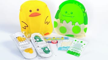 Two plush toys, one yellow and one green, with accompanying packaged items.