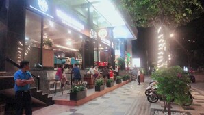 A restaurant with outdoor seating, potted plants, and a motorcycle parked nearby. - The Coast Hotel Vung Tau (Ho Chi Minh City)