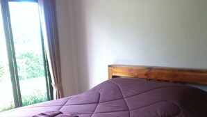 A bed with a wooden headboard, a purple bedspread, and a folded blanket on the side. - Dang Ky Resort (Cha-am)