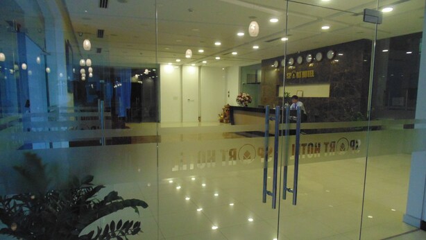 A modern hotel lobby with a reception desk, a large potted plant, and a glass partition. - Sport Hotel (Hanoi)