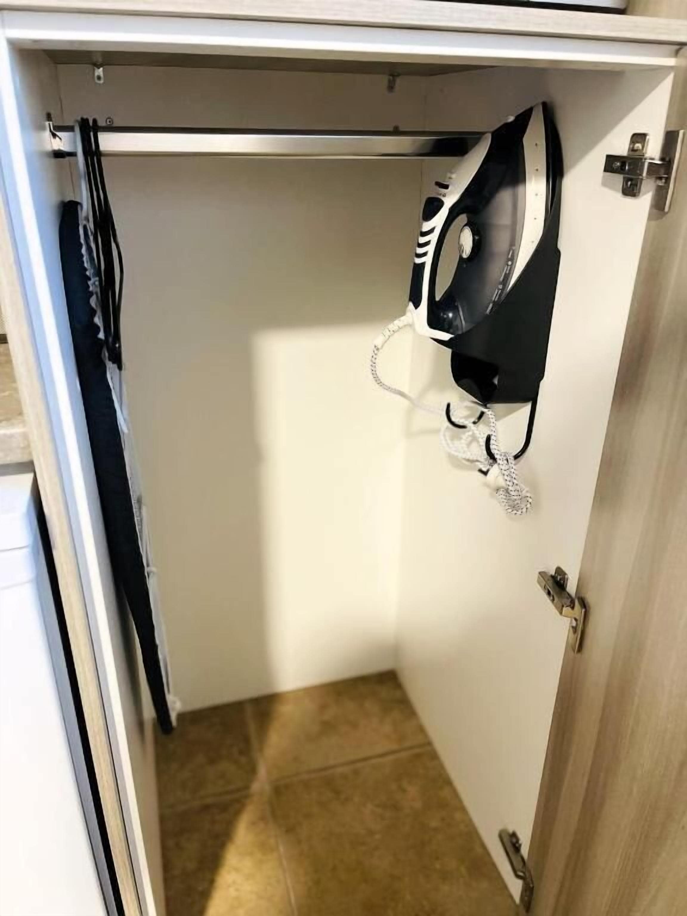 A closet with a hanging garment bag and a coat rack.