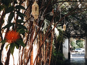 Un paseo techado con faroles colgantes y plantas de bambú.