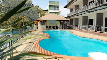 Relax by the pool surrounded by comfortable lounge chairs and umbrellas.