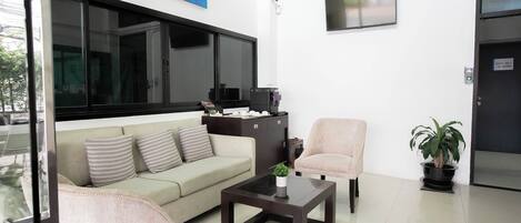 Una sala de estar moderna con sofá, sillón y mesa de centro.