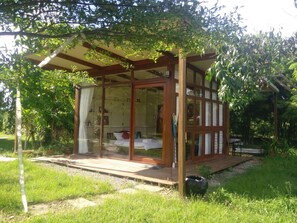 A small, private cabin with a glass door and windows, a wooden deck, and a pergola. - Ban Bang Home Resort (Phetchaburi)