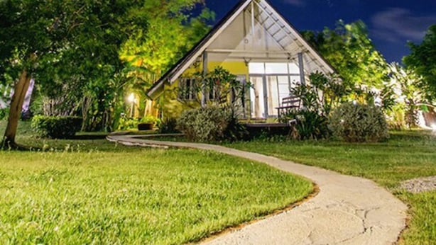 A house with a sloped roof, surrounded by lush greenery and a clear night sky. - Ban Bang Home Resort (Phetchaburi)