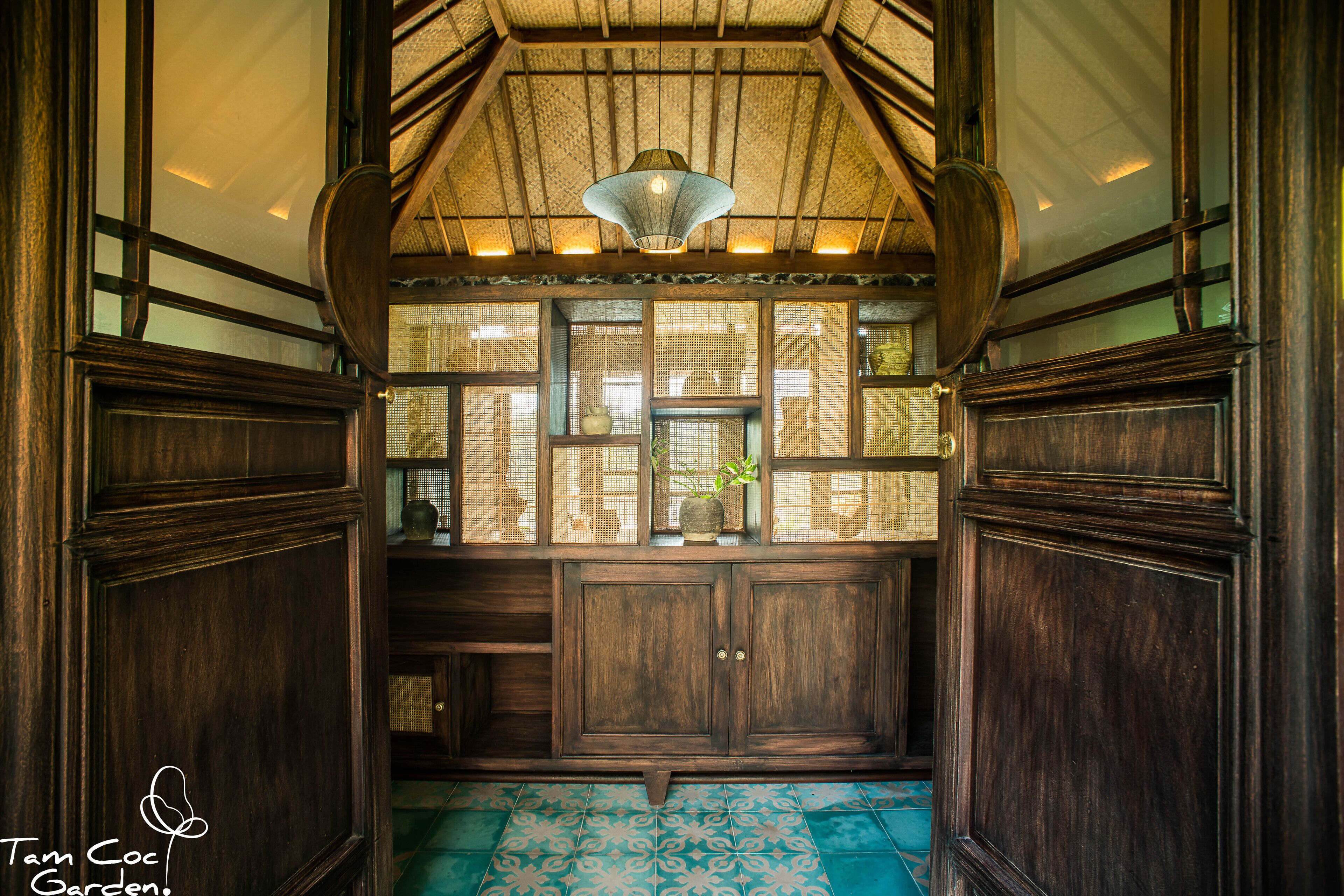 A traditional wooden interior with a sloped ceiling, a hanging light fixture, and a patterned floor.