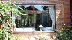 Una habitación con una ventana grande, una cama y una lámpara.