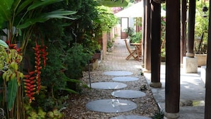 Un sendero en el jardín con piedras para pisar, rodeado de abundante follaje y plantas.