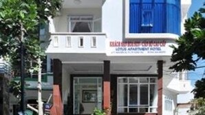 Un edificio de varios pisos con una fachada azul destacada y un letrero del Lotus Apartment Hotel.