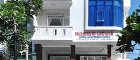 A multi-story building with a prominent blue facade and a sign for the Lotus Apartment Hotel.