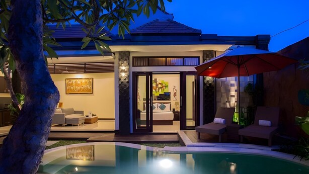 Une maison moderne dotée d’une piscine, d’un coin repas et d’un salon avec une grande fenêtre.