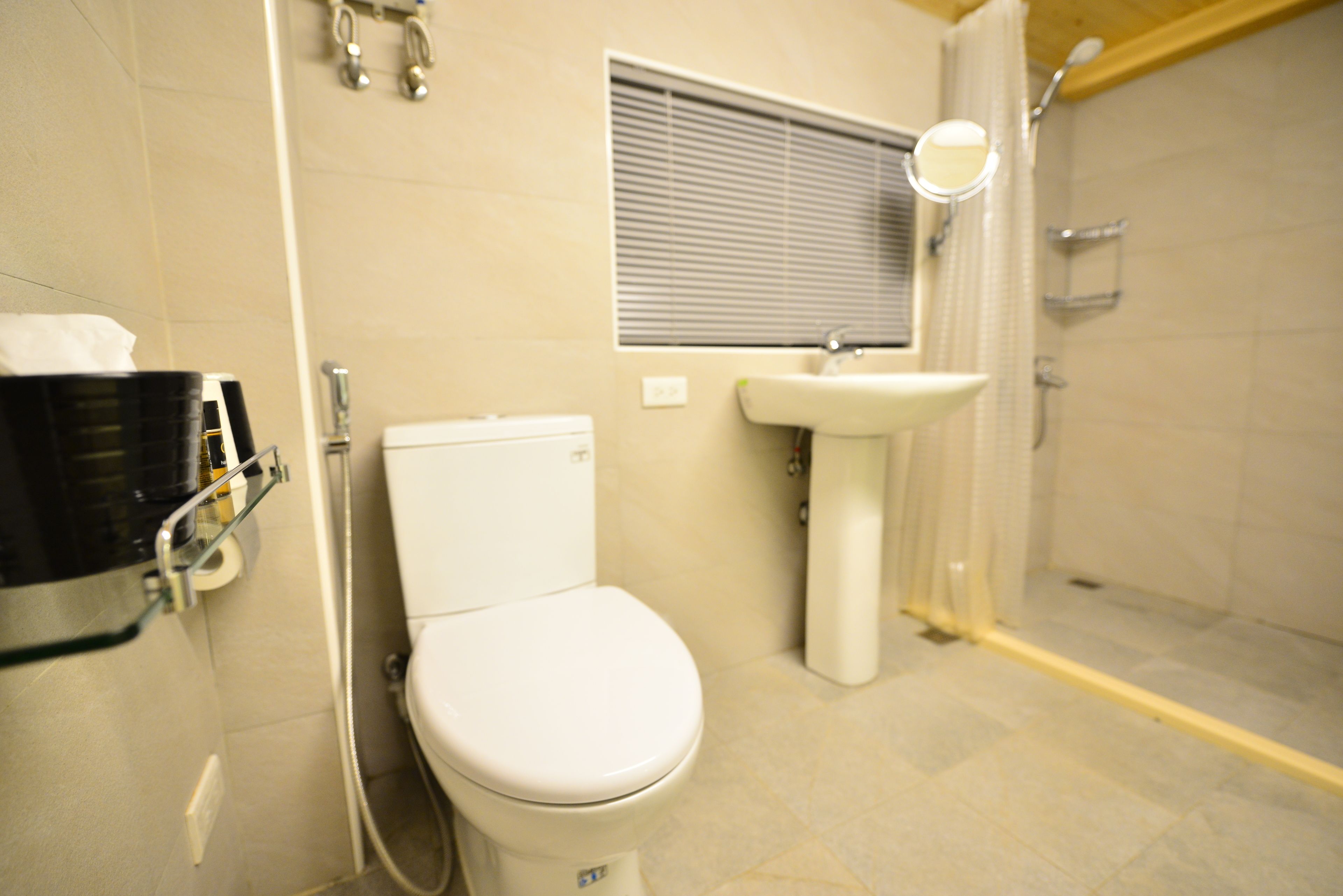 A bathroom with a toilet, sink, and shower.