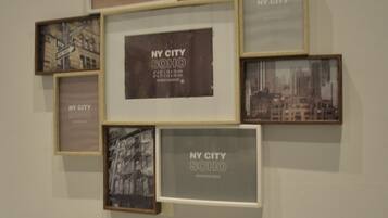 A wall with multiple framed photographs of New York City, arranged in a grid pattern.