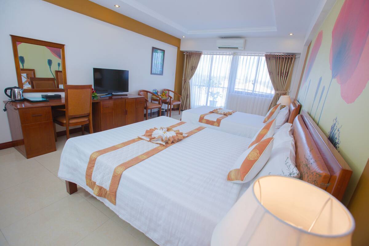 Deluxe Triple Room, Partial Sea View | Minibar, in-room safe, desk, blackout drapes