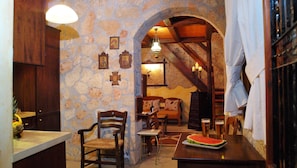 A cozy dining area with stone walls, wooden furniture, and a rustic ambiance. - W Suites Annex by Estia (Hersonissos)