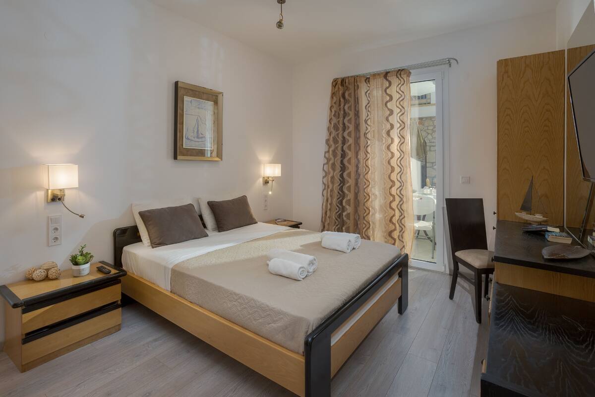 Een hotelkamer met een bed, nachtkastjes, een bureau en een stoel.