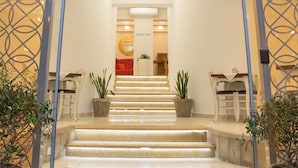Een hotelentree met een bord waarop 'CAMELOT ROYAL BEDS' staat.