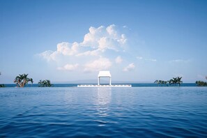 Alberca al aire libre, sombrillas en la alberca y camastros