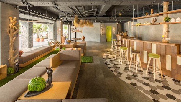 A modern interior with a bar area, seating, and a mix of natural and geometric decor.