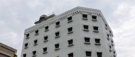 Un edificio de varios pisos con fachada blanca y muchas ventanas.