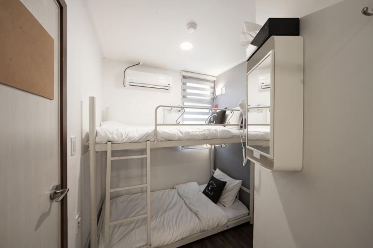 Dormitorio con literas, escritorio y ventana.