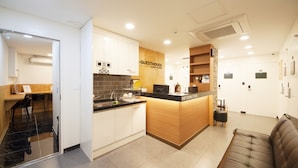 Eine moderne Hotelhalle mit Rezeption, Sitzbereich und einer Küchenzeile.