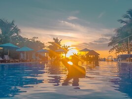 Una piscina al aire libre, sombrillas, tumbonas