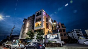 A multi-story hotel with a modern design, featuring balconies and a prominent sign. - Cheonjiyeon Hotel (Seogwipo)