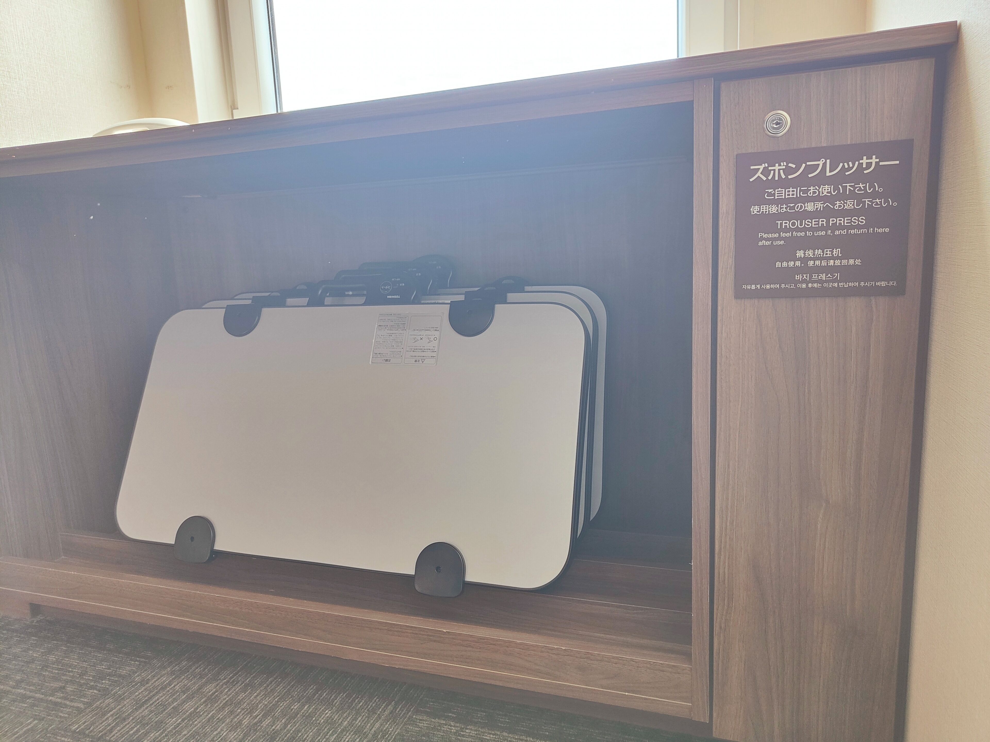 Un meuble en bois contenant une valise blanche.