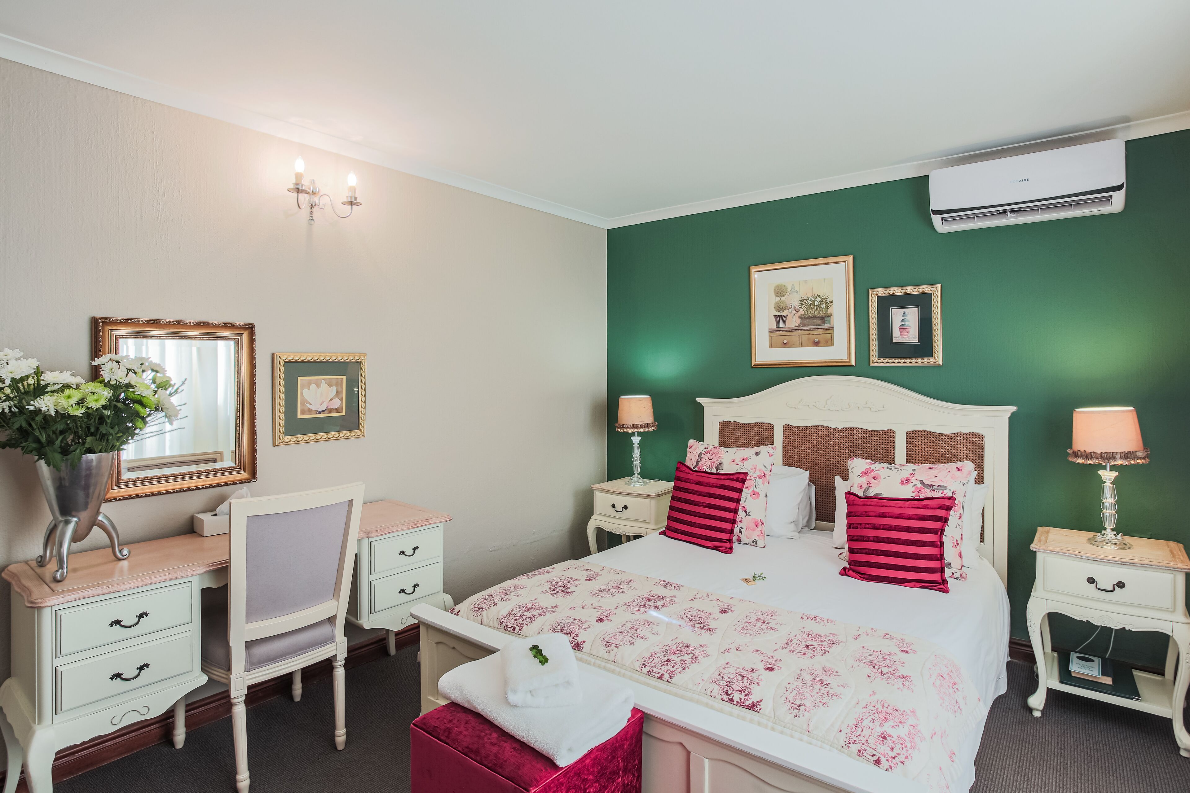 A neatly arranged bedroom with a bed, bedside tables, a dresser, and a chair.