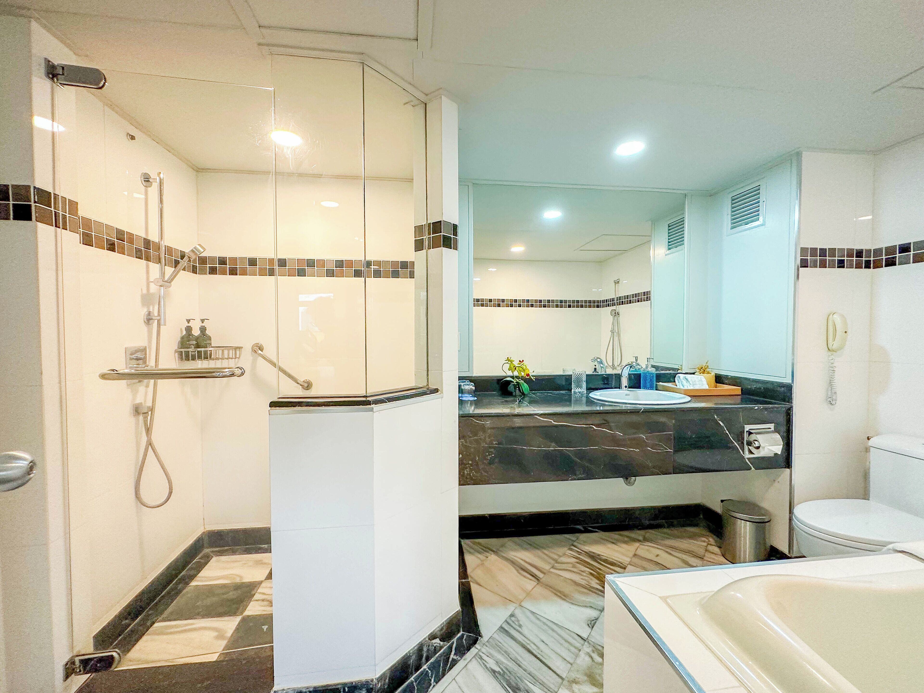A bathroom with a shower, toilet, sink, and bathtub.