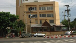 A multi-story building with a flat facade, a ground-level entrance with a small overhang, and a parking area in front. - Life In Town Chiangmai (Chiang Mai)