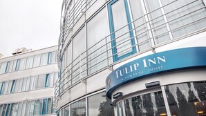 Un moderno edificio de hotel con un llamativo letrero del Tulip Inn en Messe Múnich.
