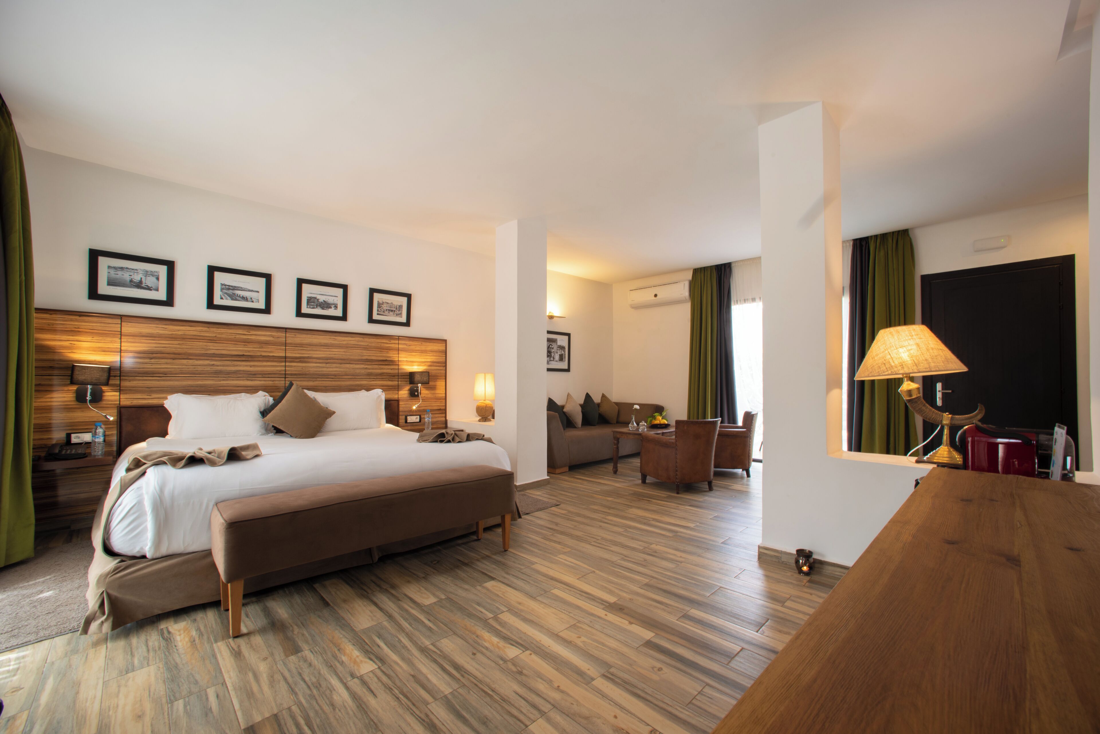 Una habitación de hotel con una cama grande, un cabecero de madera, un escritorio y una silla.