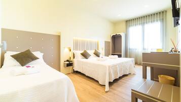 Une chambre d’hôtel avec deux lits, un bureau et une télévision.